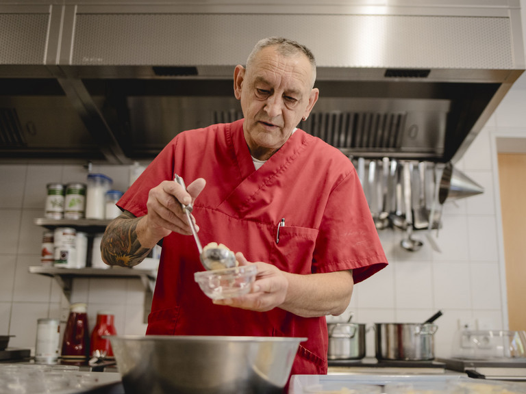Koch Alfons Lauser aus dem Immanuel Seniorenzentrum kläre Weist bei seiner täglichen Arbeit