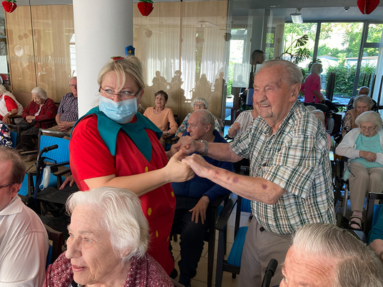 Ein Bewohner und eine Mitarbeiterin tanzen | Immanuel Haus am Kalksee | Seniorenzentrum | Erdbeerfest